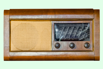 Old tube tabletop radio in wooden case, on isolated pale green background with clipping path.