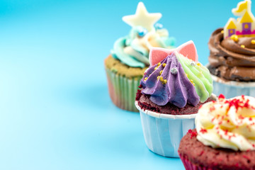 Many sweet colored cupcakes for birthdays, Merry Christmas and New Year 2020 on a blue background.