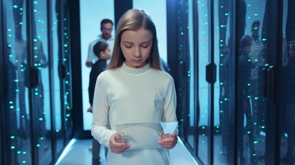 Young girl IT engineer using invisible digital pad learning modern computer technology and network science staying at server room of data center. Future children concept. - Powered by Adobe