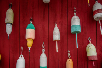 Colorful lobster buoys on red wall
