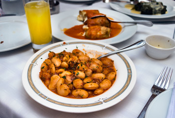 A traditional greek dish Fasolia - Giant beans on a tavern table, outdoors.