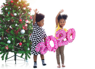 Happy African boy and girl holding pink number 2020 balloon and Christmas tree on white background, Christmas time