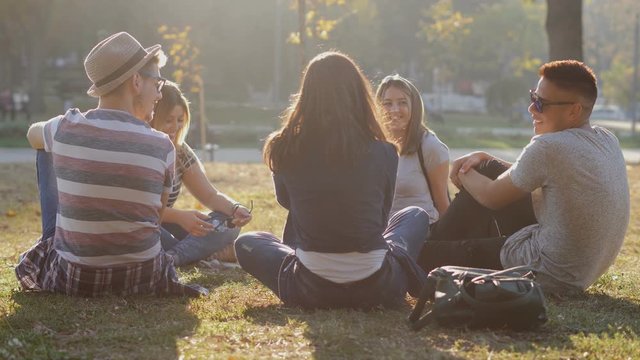 Group of teenage friends hang out at city park