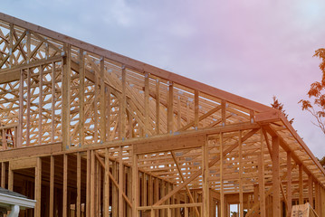 Obraz premium New construction home framing against a blue sky