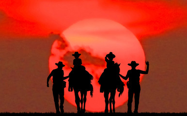 silhouette cowboy and horse on blurry colorful sunset sky.