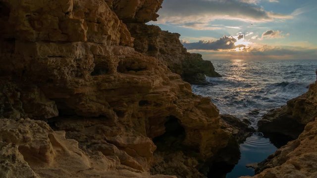 Beautiful nature video landscape. Sunset time lapse on the sea. Grotto into the rock. 
