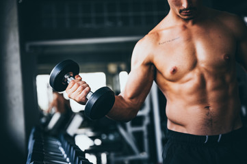 Fototapeta na wymiar Strong man exercising in the sport gym