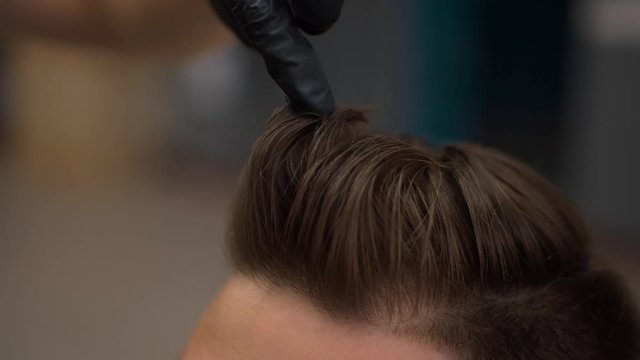 Client during beard shaving in barber shop. Hairdressing services. man cuts hair at a hairdresser-stylist in barbershop. scissors comb close-up Details of trimming. Cropped closeup  barber trimming