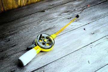 Ice fishing tackle on the grey wooden table