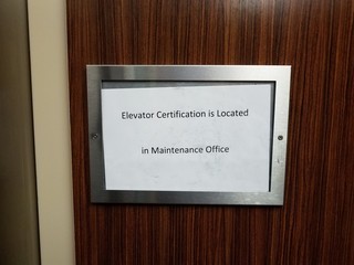 paper elevator certification is located in maintenance office sign