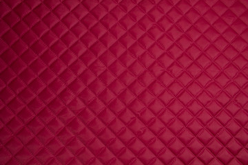 Quilted fabric. The texture of the blanket.	Red textile