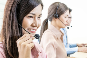 Call center, Service desk consultant talking on hands-free phone, Group of young employee working with a headset. Office and business concept