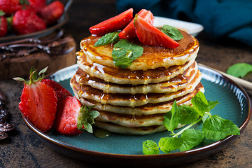 Classic American Breakfast pancake with honey and berries. Still life of lush pancakes, honey and strawberries.