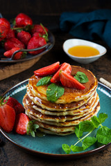 Classic American Breakfast pancake with honey and berries. Still life of lush pancakes, honey and strawberries.