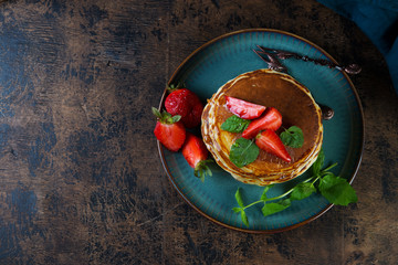 Classic American Breakfast pancake with honey and berries. Still life of lush pancakes, honey and strawberries. Top view