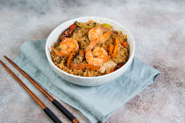 Chahan fried rice with egg, vegetables and shrimp on the lighter concrete background . Horizontal photo.