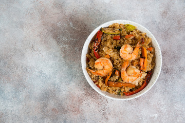Chahan fried rice with egg, vegetables and shrimp on the lighter concrete background . Horizontal photo with copy space& Top view