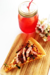Italian food, piece of bacon and beef pizza with iced tea 