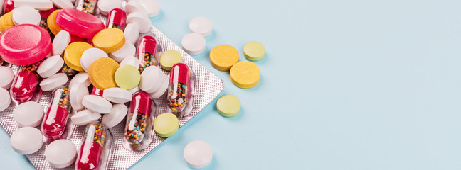 Colorful pills on a pastel blue background. Flat lay, top view, overhead, mockup, template. Pharmacy and medical concept