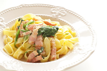 Italian food, spinach and bacon fettuccine flat pasta on plate