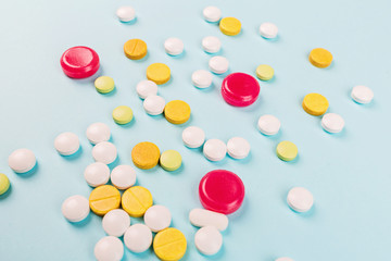 Colorful pills on a pastel blue background. Flat lay, top view, overhead, mockup, template. Pharmacy and medical concept