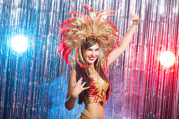 Carnival, belly dance and holiday concept - Beautiful female samba dancer wearing gold costume and smiling