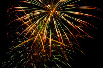 Bright festive fireworks against the night sky. Firework Fiery flowers during the holiday.