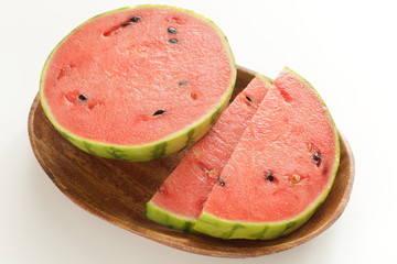 sliced watermelon on wooden plate on white background with copy space