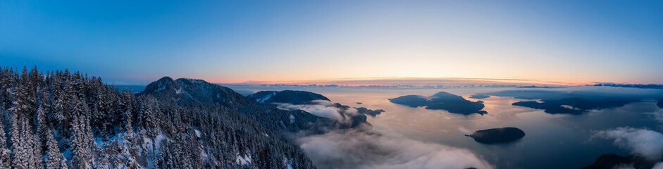 Aerial Panoramic View of Canadian Mountain Landscape on the Pacific Ocean Coast during a colorful sunset. Taken in Howe Sound near Vancouver, British Columbia, Canada.