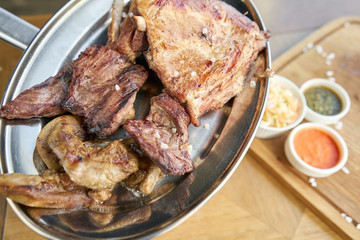 Various grilled meat set heated on coals. Barbecue restaurant menu. Many different food on the table. Dinner party or Banquet