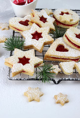Obraz na płótnie Canvas Biscotti natalizi Linzer fatti in casa. Biscotti con pasta frolla e marmellata di lamponi su fondo bianco.