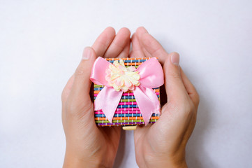 Hands holding gift box on white background top view.