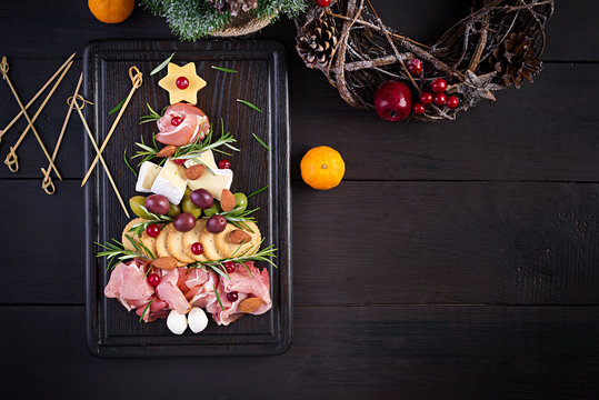 Antipasto Platter With Ham, Prosciutto, Salami, Cheese,  Crackers And Olives On A Wooden Background.  Christmas Table. Top View, Overhead