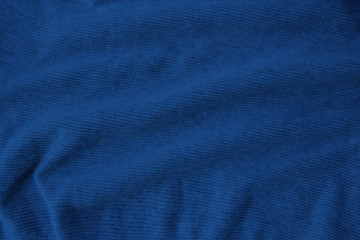 Fototapeta na wymiar Classic blue sample of a thin knitted woolen fabric with soft folds, the concept of fashion and style, needlework, copy space