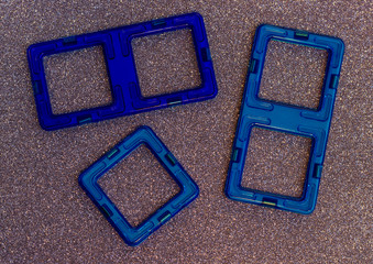 Children's magnetic constructor. Colorful details and geometric shapes on a blurry shiny background.