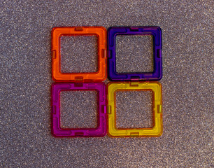 Children's magnetic constructor. Colorful details and geometric shapes on a blurry shiny background.