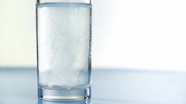 Aspirin bubble water glass drink headache medicine, background.