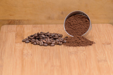 Coffee beans and ground powder on a wooden background. Top view with copy space