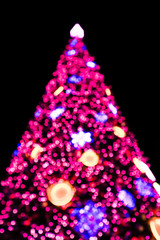 Defocused Christmas tree with lights glowing