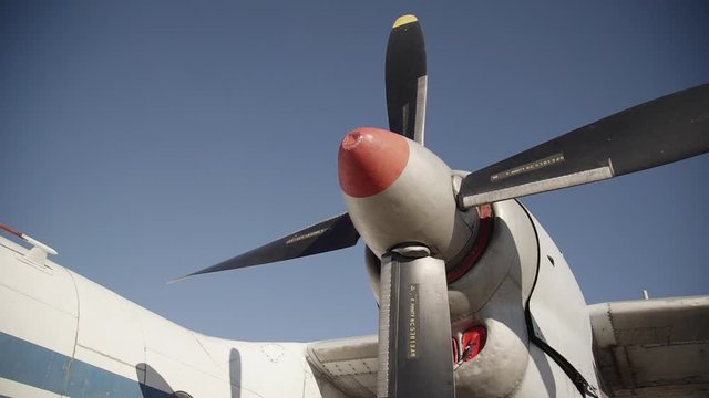 closeup shot of resting propeller of plane standing on land in airport or runway. aircraft, jet, air transportation, aviation, daylight, engineer, power, flight concept
