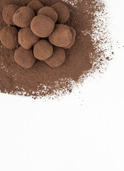 Vertical flat lay of chocolate truffles piled in a corner. Pastry concept.