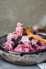 Homemade banana ice cream with black berries, blackcurrant in bowl   on wooden table. Vegan, vegetarian healthy food. 