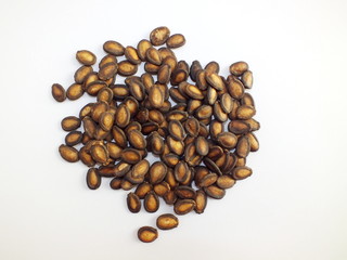Natural dried melon seeds on white background.