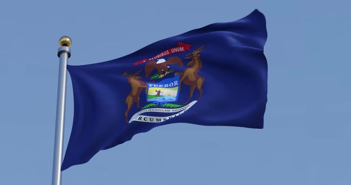 Michigan flag blowing in the wind in front of a blue sky