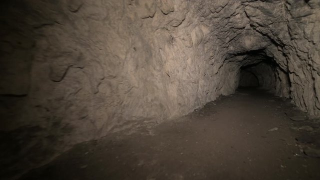 Speleology artificial cave dark tunnel excavation underground. Old adit for the extraction of metal and rocks