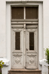 Old white ornate wooden white door with peeling paint
