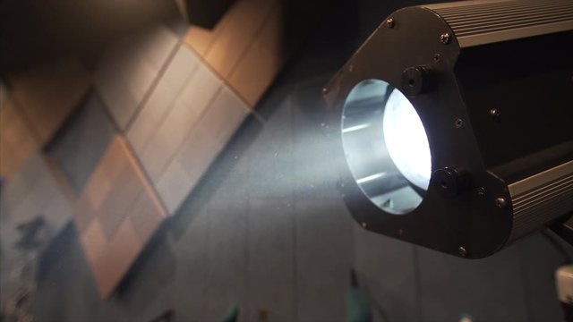 Closeup view of big cinema spotlight and dust floating in the air seen at light