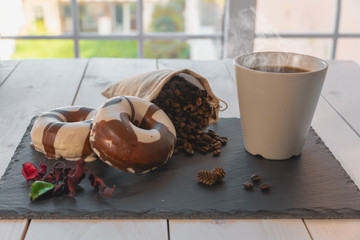 Desayuno con café y donuts sobre plato de pizarra