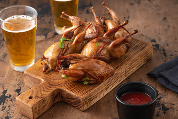 Delicious fried roasted quails with herbs, spices and beer. Grilled quails. Holiday Christmas and...