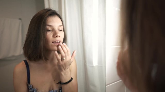 A young girl does makeup in the bathroom. 4k video